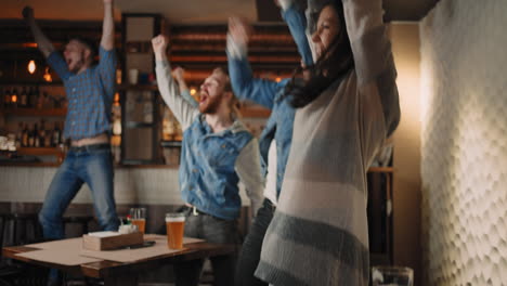 A-group-of-men-and-women-in-a-pub-together-cheer-for-their-national-team-at-the-World-Cup-in-football-basketball-hockey.-Celebrate-the-goal-scored-the-puck.-Celebrate-the-victory